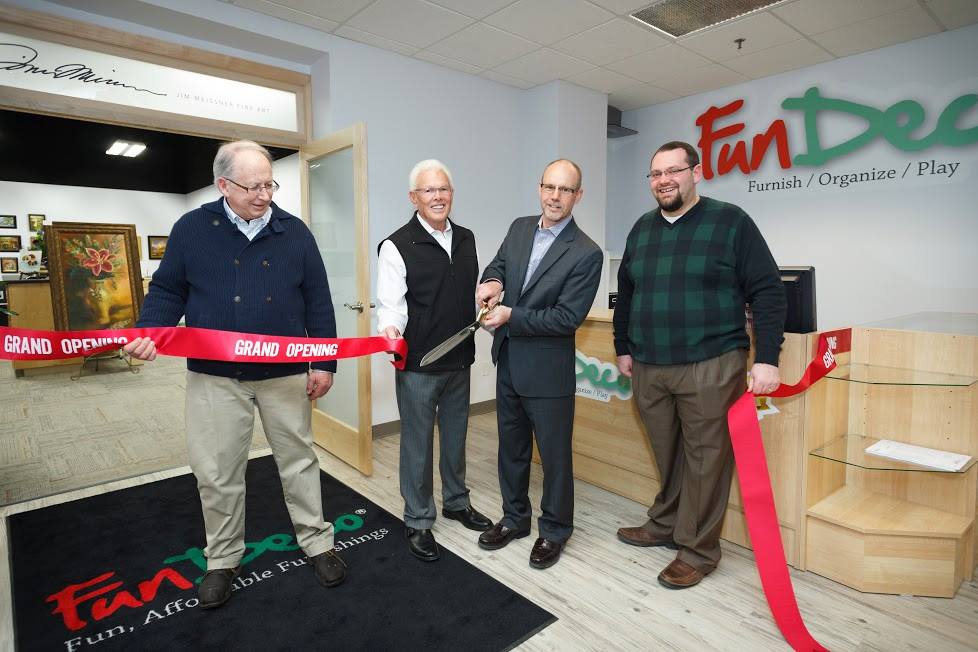 FunDeco Owners clipping Grand Opening ribbon in office